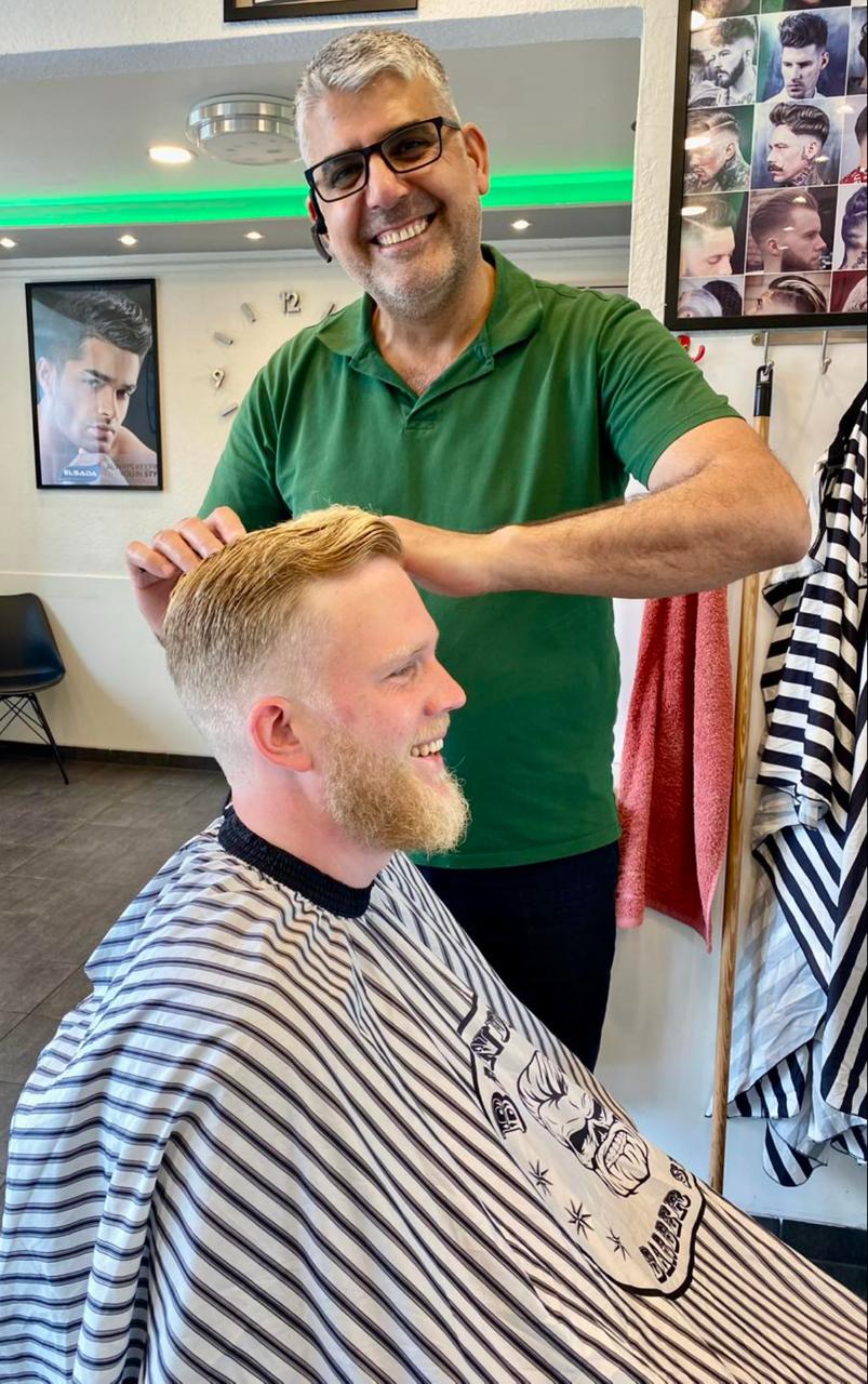 Abdul fra Tiptop Klip sammen med en smilende kunde efter et klip